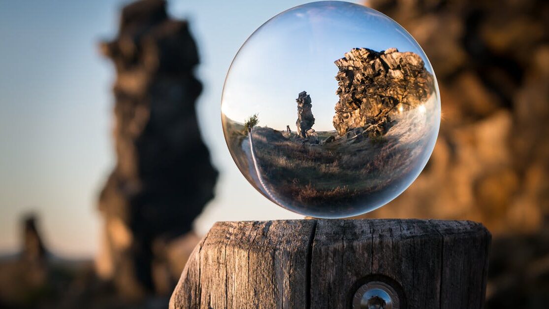 A mesmerizing view through a crystal sphere capturing a rocky landscape at dusk. Perfect for nature and abstract themes.